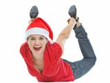 Cheerful young woman with Christmas hat laying on floor