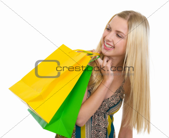 Smiling teenage girl with shopping bags looking on copy space
