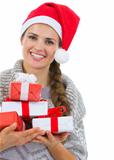Smiling woman in Santa hat with Christmas gift boxes