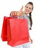Closeup on showing thumbs up woman hand with shopping bags