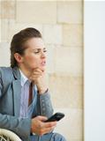 Concerned business woman holding mobile phone