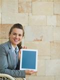 Smiling business woman showing tablet PC