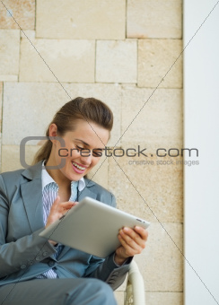 Smiling business woman using tablet PC