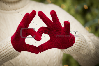 Woman in Sweater with Seasonal Red Mittens Holding Out a Heart Sign with Her Hands.