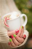 Woman in Sweater with Seasonal Red and Green Nail Polish Holding a Warm Cup of Hot Cocoa.