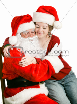 Girl Sitting on Santas Lap Getting a Hug