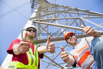 two power line workers with thumbs up