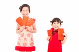 happy chinese new year. smiling asian little girls holding red e