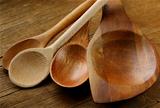 Empty wooden spoons on a wooden background