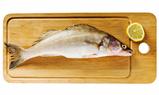 Pike perch on a wooden kitchen board, it is isolated on white