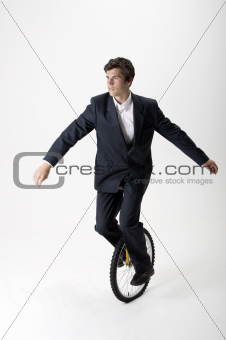 Businessman riding unicycle
