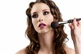 girl getting made-up by hands with brushes, looks at right