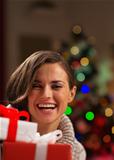 Happy young woman looking out from Christmas gift boxes