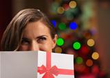 Girl hiding behind Christmas postcard