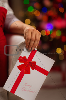 Closeup on Christmas postcard in woman hand