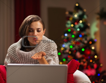 Happy young woman having Christmas video chat with lover