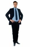 Full length view of a young businessperson posing with hands on his waist