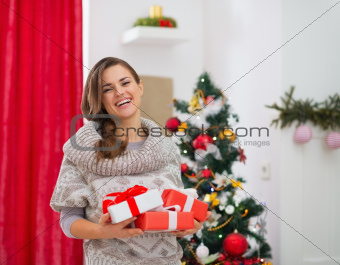 Portrait of happy woman with present boxes near Christmas tree