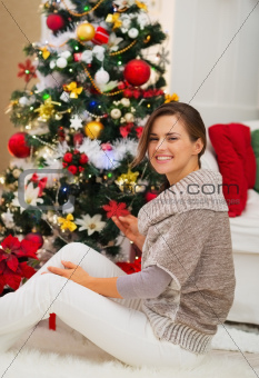 Happy young woman decorating Christmas tree