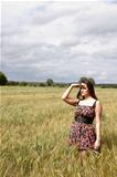 An attractive lady standing  in a field