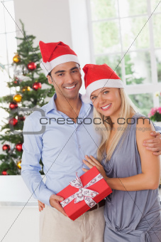 Attractive couple at christmas holding a gift
