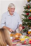 Grandfather carving the turkey for christmas dinner