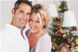 Couple embracing at christmas by dinner table