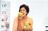 Mature Indian woman eating fruits