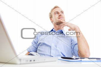 young man at office, sitting leaning back daydreaming
