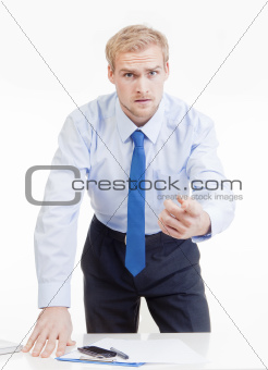 angry boss standing behind desk, gesticulating, accusing, blaming