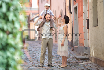 Happy young family in city street on beautiful summer day