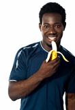 Young fit guy eating banana