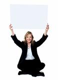 Seated female employee holding white clipboard over her head