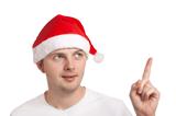 Young man in santa hat pointing up