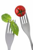 basil leaves and tomato on forks