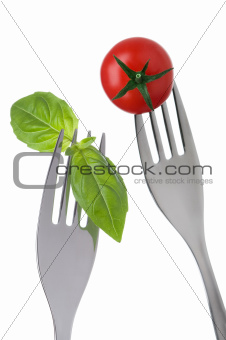 basil leaves and tomato on forks