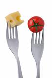 tomato and cheese on forks against white