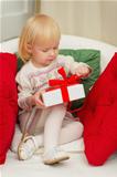 Baby sitting on chair and open Christmas gift box