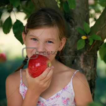 Little girl biting into an apple