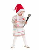 Baby girl in Christmas hat dancing with microphone