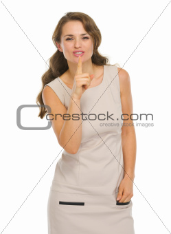 Young woman in dress showing shh.. gesture