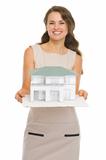 Smiling architect woman showing scale model of house