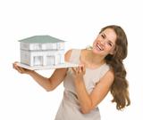Smiling woman landlord with scale model of house