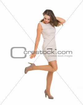 Young woman in dress adjusting shoe