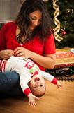 Young Attractive Ethnic Woman With Her Newborn Mixed Race Baby Near The Christmas Tree.