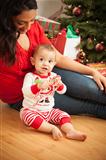 Young Attractive Ethnic Woman With Her Newborn Baby Near The Christmas Tree.