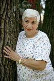Senior Woman Leaning on Tree