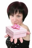 The girl holds in a hand a gift in pink packing
