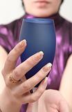 Dark blue glass with wine in female hands