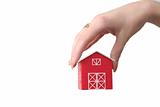 The red house is in a female hand on a white background